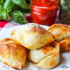 small pastries on a plate with sauce and herbs