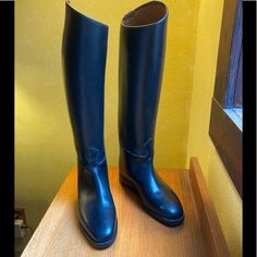 a pair of black boots sitting on top of a wooden table