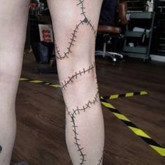 two people with tattoos on their legs and one has a cross stitched design on the leg