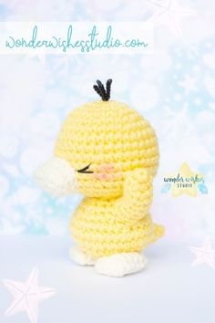 a yellow crocheted stuffed animal sitting on top of a white table next to stars