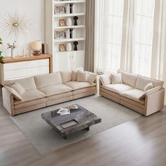 a living room with two couches and a coffee table in front of a window