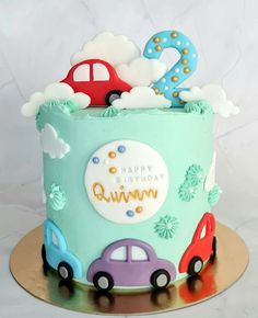 a birthday cake decorated with cars and clouds