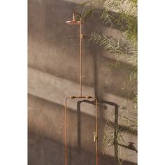 a tall metal water spigot sitting next to a plant