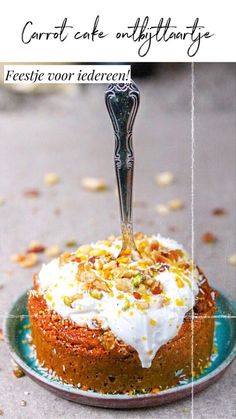 a carrot cake with white frosting and nuts on top