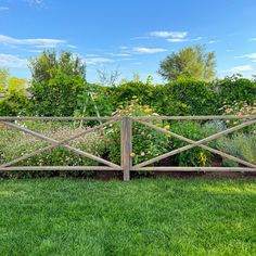 a wooden fence surrounded by lush green grass