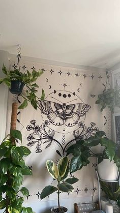 some plants are sitting on a shelf in front of a wall with an intricate design