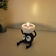 a lit candle with an evil looking face on it