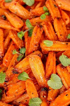 a pile of cooked carrots with herbs on top