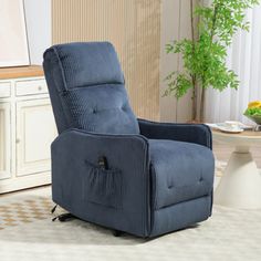 a blue recliner chair sitting on top of a rug in front of a table