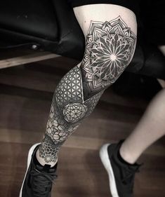 a woman's leg with a tattoo on it and an intricate flower in the center