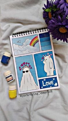 a notebook with pictures of polar bears on it next to some paint bottles and flowers