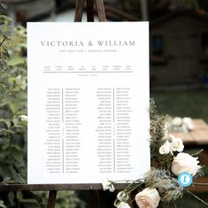 a wedding seating chart on a easel with flowers and greenery in the foreground