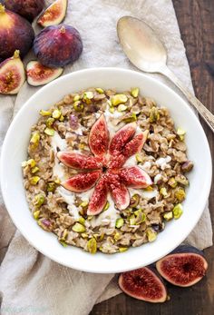 a white bowl filled with oatmeal topped with figs and pistachio