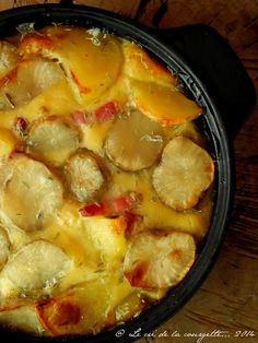 a casserole dish with potatoes and meat in it on a wooden table top