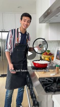 a man in an apron standing next to a stove