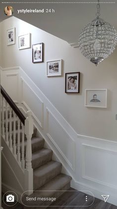 a staircase with pictures on the wall and a chandelier