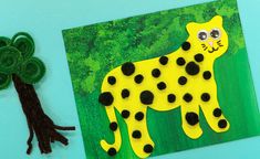 a paper cut out of a cheetah next to a green leafed tree