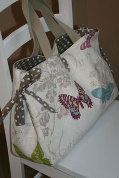 a purse sitting on top of a white chair next to a wooden table with polka dots and butterflies