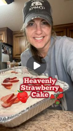 a woman holding up a cake with strawberries on it and the words heavenly strawberry cake