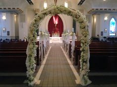 an aisle decorated with white flowers and greenery at the end of a wedding ceremony