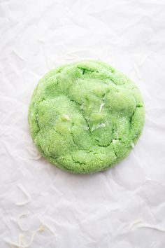 a green cookie sitting on top of white paper