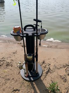 two fishing rods are hooked up to the water's edge while another rod sits on top of it