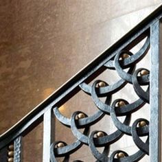 a close up of a metal hand rail on a stair case with decorative iron work