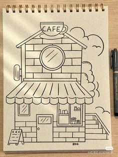 a drawing of a coffee shop on a piece of paper next to a marker pen