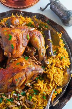 two chicken legs on top of yellow rice