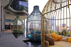 a birdcage sitting on top of a patio next to a swimming pool in front of a tall building