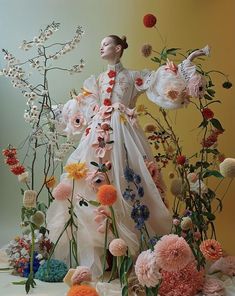 a woman in a white dress surrounded by flowers