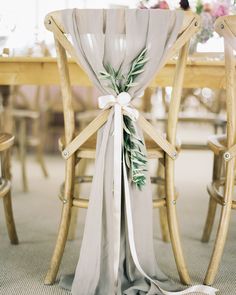 the back of a wooden chair with a white sash on it