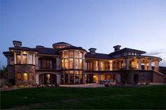 a large house with lots of windows and lights on it's front lawn area