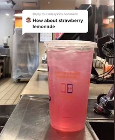 a pink drink sitting on top of a metal counter