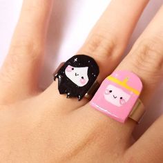 a woman's hand with two rings on it, one has a princess and the other has a bear