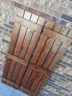 an open wooden door on the side of a brick wall in front of a building