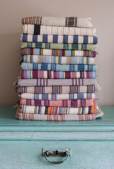 a stack of towels sitting on top of a blue dresser