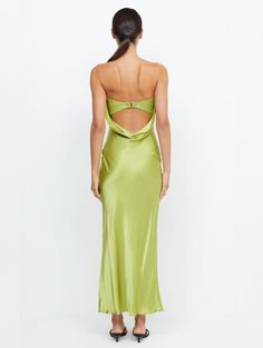 the back of a woman wearing a lime green satin slip dress with an open slit