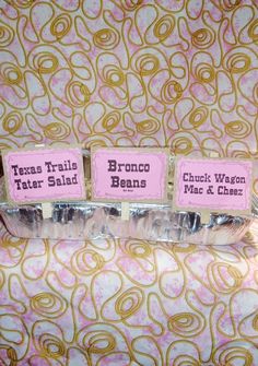 three pieces of food sitting on top of a table covered in pink and gold paper