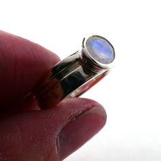 This gorgeous moonstone is set in a wide band with a cut out decorative element that goes all the way round the band. The same cut out also features on the bezel. The 6mm round moonstone is bezel set on a 6mm wide sterling silver band.The simplicity of this ring, matched with the blue rainbow hues of the moonstone, makes it a perfect piece to add to your collection.I can add engraving to the inside of the ring, like a date, or name. It is an additional $20, if you would like this, please choose Polished Moonstone Ring With Round Stone For Anniversary, Silver Moonstone Ring With Round Cut, Anniversary Moonstone Ring With Bezel Setting, Silver Solitaire Moonstone Ring Round Cut, Silver Moonstone Ring With Bezel Setting, Modern Moonstone Ring With Bezel Setting In Sterling Silver, Modern Sterling Silver Moonstone Ring With Bezel Setting, Unique Silver Cabochon Moonstone Ring, Nickel-free Sterling Silver Moonstone Ring