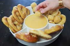 a person dipping sauce into some fried food