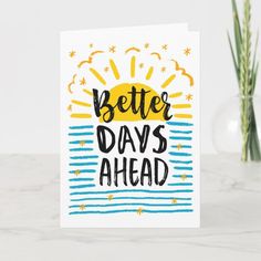 a card with the words better days ahead in black and yellow on it next to a vase filled with flowers