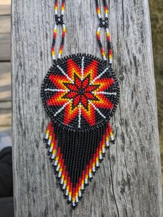 a beaded necklace hanging on a wooden post