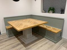 a corner table with two benches in front of it and a clock on the wall