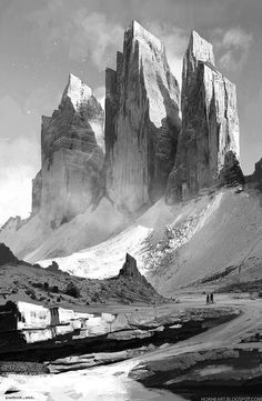 black and white photograph of mountains with people walking on the road in front of them