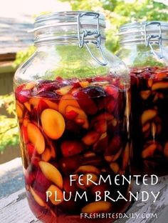 two jars filled with fruit sitting on top of a wooden table