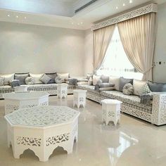 a living room filled with lots of white furniture