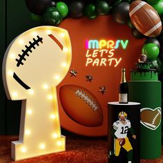 a football themed party with balloons, lights and sports items in the shape of letters