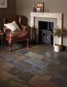 a living room with a chair, fireplace and pictures on the wall in it's corner