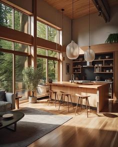 a living room filled with furniture and lots of windows next to a wooden floored kitchen